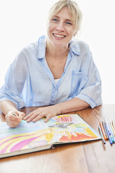 Cécile Berland – Art-thérapeute pluriexpressionnelle dans les hauts de france Cécile Berland, art-thérapeute pluriexpressionnelle, dessinant avec des crayons de couleur lors d’une séance créative.